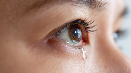 Obraz premium A close-up shot of a tear rolling down a person's eye