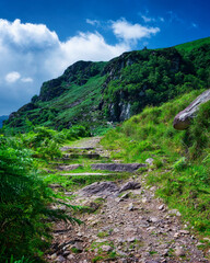 Stony pathway ascending Strickeen mountain in County Kerry, Ireland during the daytime.
