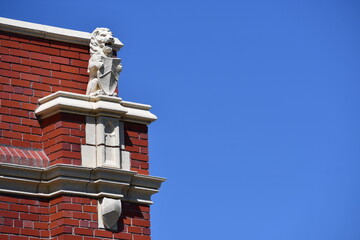 Obraz premium Fancy lion statue on old brick building.