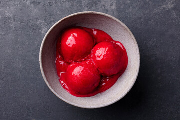 Ice cream cherry, raspberry, strawberry, cranberry , red sorbet, scoop, black stone background. copy, text space. Close up.