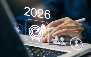 A businessman using a digital device to plan for future business strategies, with icons representing target goals, team collaboration, and financial growth for the year 2026.