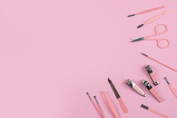 Manicure tools on a delicate pink background with space for text