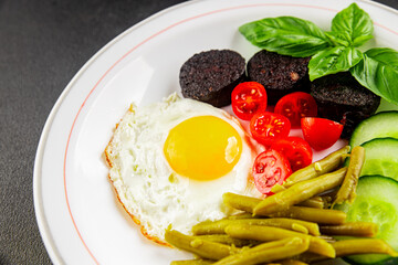 English breakfast fried egg, black pudding, vegetables, beans fresh delicious gourmet food background on the table rustic food top view copy space