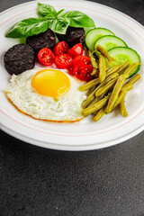English breakfast fried egg, black pudding, vegetables, beans fresh delicious gourmet food background on the table rustic food top view copy space