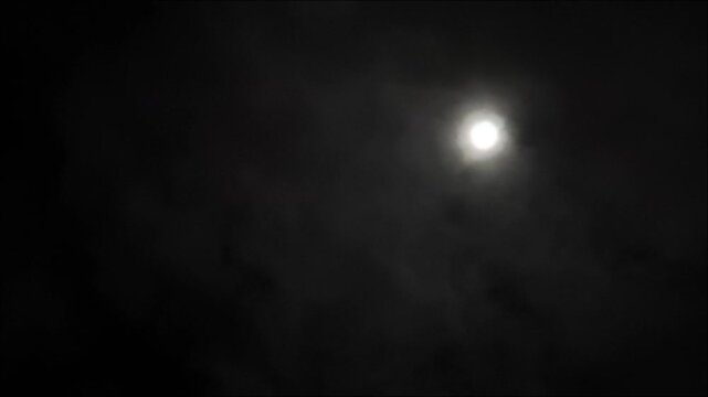 Thin clouds try to cover the moon at night