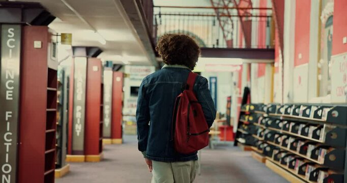 Man, education and student walking in library for study material, textbook search and knowledge. Back, person and backpack on college campus for assignment information, thesis citation or scholarship