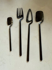 Fragment of black cutlery set on light background