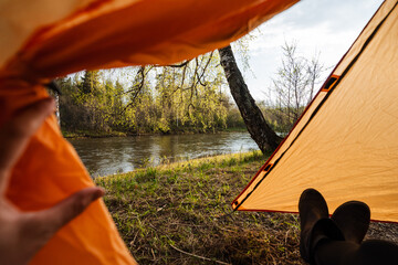 Picture a tranquil campsite located next to a gracefully flowing river, where a cozy tent awaits, perfect for anyone looking for an adventurous yet peaceful escape into the stunning beauty of nature