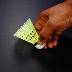A badminton rocket holding hand black background close-up view copy space, A shuttlecock racket...