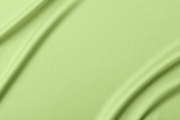 Abstract pistachio color background. Light pistachio color silk satin fabric with soft wavy folds