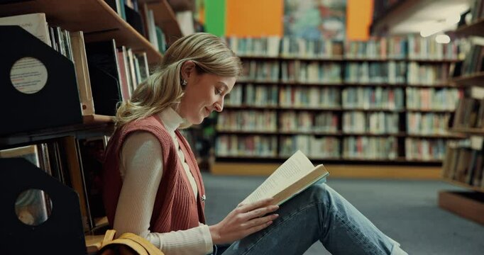 Happy woman, student or laughing with story in library for comedy, funny joke or humor. Female person, learner or reading with smile, book or novel on floor for comic, genre or amusement by bookshelf