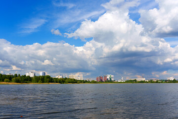 Panoramic View of Urban Skyline with Cloudy Sky Over Lake