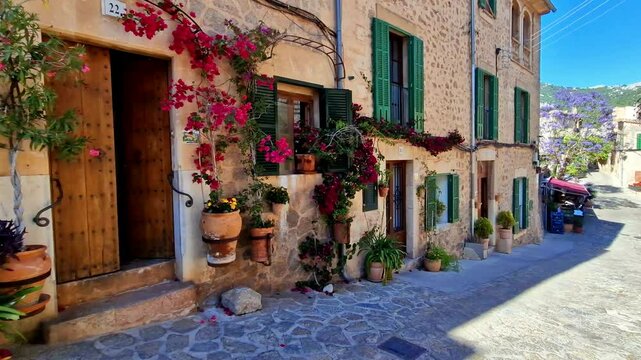 Valldemossa Mallorca floral street with traditional stone houses and flower pots decoration. Spain Balearic Islands picturesque village. Slow travel destination 