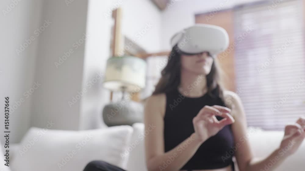 Poster a woman immersed in virtual reality at home with vr headset and gesture control. she wears a vr head