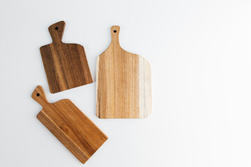 Wooden cutting boards arranged creatively on a clean white surface