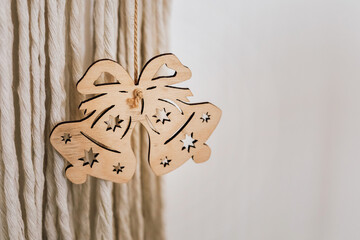Wooden bell ornament displayed on a textured wall adding charm to holiday decorations