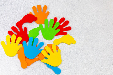 Colorful hand shapes scattered on a gray surface providing a fun and creative atmosphere for the...