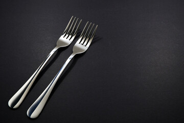 set of forks pairing together isolated on black background close-up view, Food concept photography