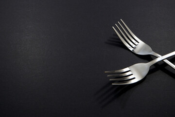 set of forks pairing together isolated on black background close-up view, Food concept photography