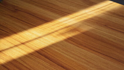 Wooden surface with warm tones illuminated by sunlight, showcasing natural grain patterns and textures, creating a serene and inviting atmosphere for design purposes