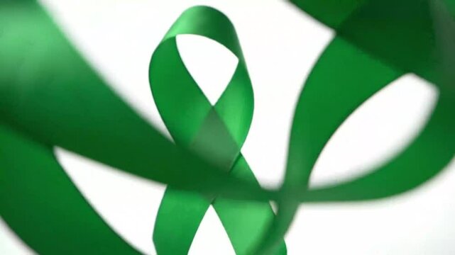 Graceful Green Ribbon Flowing and Looping Elegantly on White Background Perfect for Symbolizing Environmental Awareness and Earth Day Celebrations