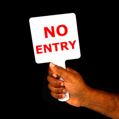 NO ENTRY sign board holding hand with black background close-up view, Sign board showing by hand on black background 