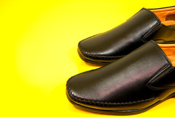 Close-up shot of black shoes together with yellow background, Selective focus, Formal leather shoes isolated 
