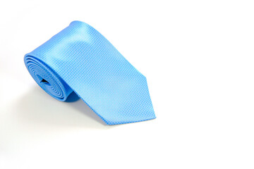 A blue tie rolled on white background closeup shot 