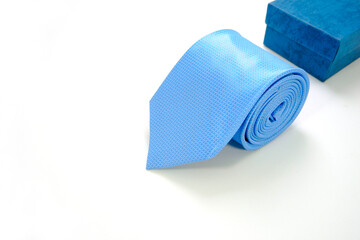 A blue tie rolled on white background closeup shot 