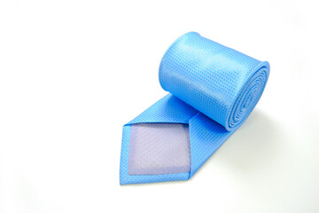 A blue tie rolled on white background closeup shot 