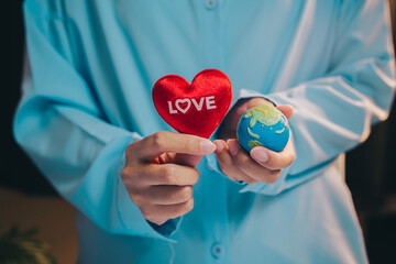 Love earth concept. Heart Shaped Symbol of Love and Earth Sphere Representing Global Compassion and Unity in Hands of Person