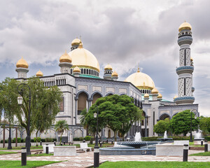 Obraz premium Stunning architecture of Jame' Asr Hassanil Bolkiah Mosque in Bandar Seri Begawan, Brunei. The golden dome glistens under a colorful sky, creating a peaceful atmosphere