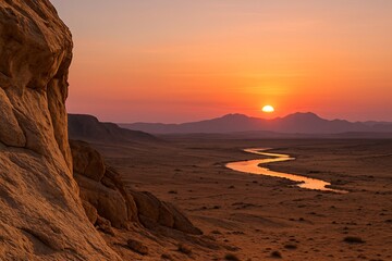 Fototapeta premium Stunning desert sunset over a winding river carving through a rocky and arid valley, with golden light illuminating the landscape and creating a dramatic and serene view