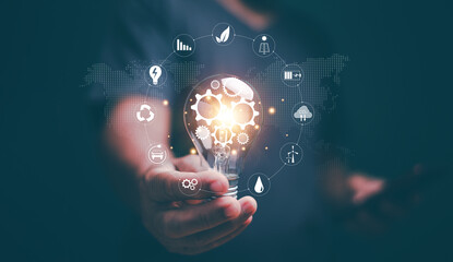 Creative ideas of saving energy and renewable power concept, Hand holding light bulb with gears inside and icons energy sources for renewable, New ideas for energy management. Alternative energy.