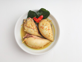 Squid with tofu filling cooked in curry sauce in white bowl