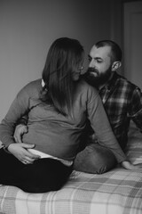 A bearded man and his blond wife during their period, tender embrace, love and care of a man for his wife in the 9th month of this period.