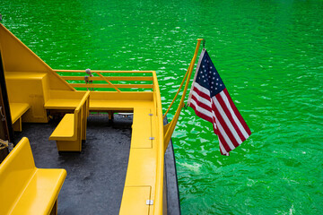 Yellow water taxi on green dye Chicago river on St Patrick's day