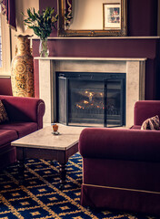 An antique open fireplace in a grand living room.