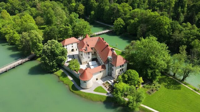 Otočec, Slovenia, a castle on the river, aerial footage, drone video a green river and castle on the island