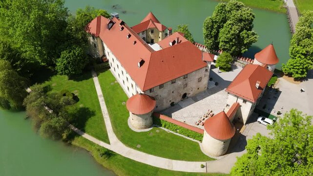 Otočec, Slovenia, a castle on the river, aerial footage, drone video a green river and castle on the island