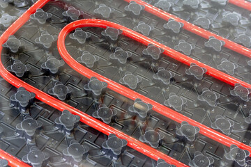 Red pipes laid out in a grid pattern for a radiant heating system