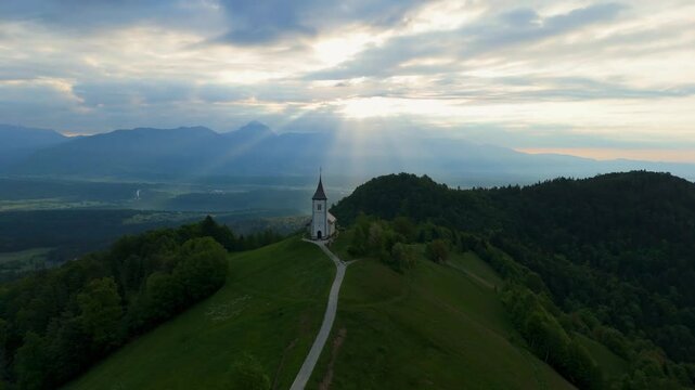 Amazing light rays above the church on the hill in Jamnik, Slovenia, saint Primus and Felician, drone video, aerial footage