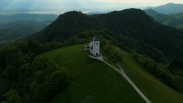 Amazing light rays above the church on the hill in Jamnik, Slovenia, saint Primus and Felician, drone video, aerial footage