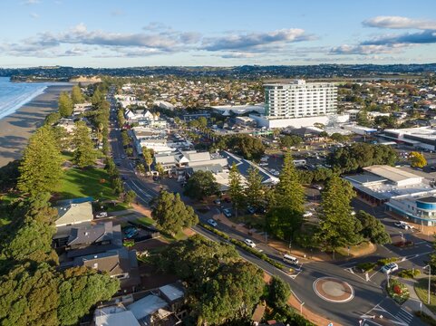 Aerial view of  Orewa, Auckland, New Zealand. The photo shows the beach, town center, and residential areas, highlighting the town's coastal lifestyle.
