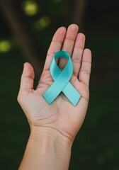 Hand Holding Teal Ribbon Symbol of Hope Sparking Awareness Photo