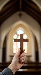 Hand Holding Wooden Cross in Church Interior Symbolizing Faith and Religion