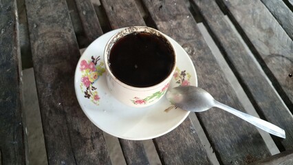 Cup of Black Coffee on Rustic Wooden Table: Simple Coffee Mug and Saucer on a Textured Wood Surface, Morning Drink