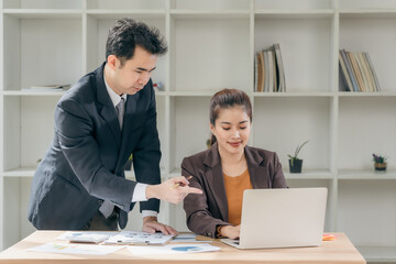 Obraz premium Business men and women discussing charts and graphs showing results of successful teamwork using laptops. Business strategy planning and brainstorming.