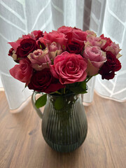 Roses in Glass Vase on Wooden Floor with Blurred Sheer Curtain in Background, in Soft Light