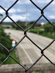 accordion wire fence with road and scenery background